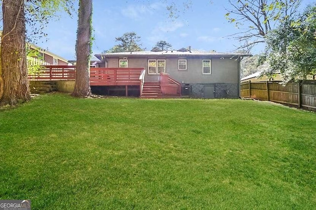 back of property featuring a wooden deck and a lawn