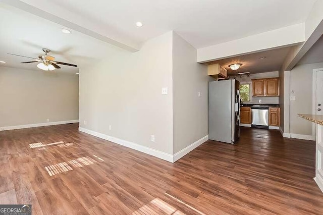 unfurnished living room with ceiling fan, beamed ceiling, and dark hardwood / wood-style flooring