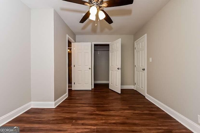 unfurnished bedroom with dark hardwood / wood-style floors, ceiling fan, and a closet