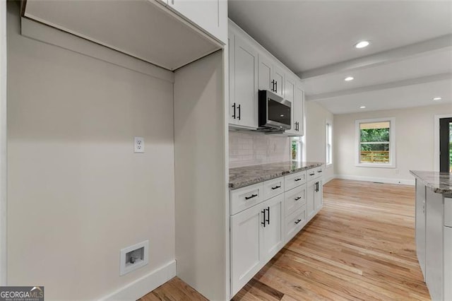 kitchen featuring light hardwood / wood-style flooring, decorative backsplash, light stone counters, and white cabinetry