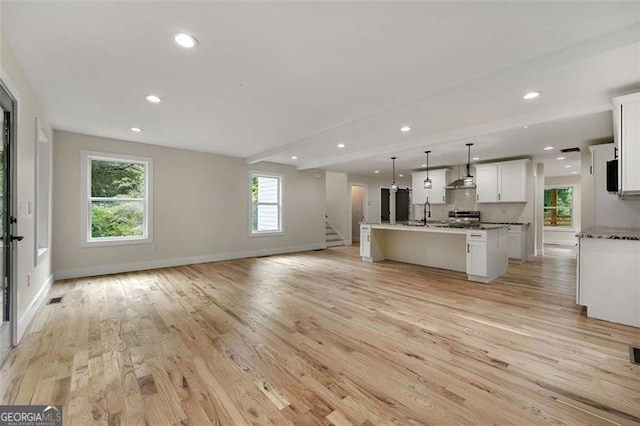 unfurnished living room with light hardwood / wood-style floors and sink