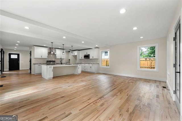 unfurnished living room featuring light hardwood / wood-style floors and sink