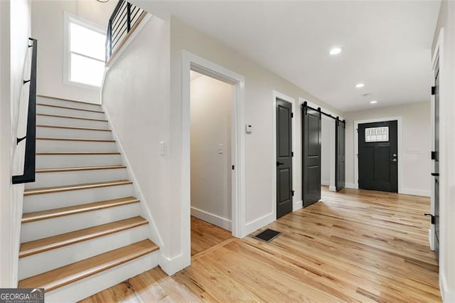 foyer with light wood-type flooring and a barn door