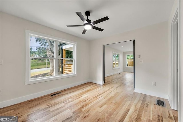 empty room featuring light hardwood / wood-style floors, plenty of natural light, and ceiling fan