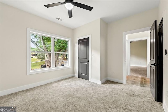 unfurnished bedroom featuring ceiling fan and light colored carpet