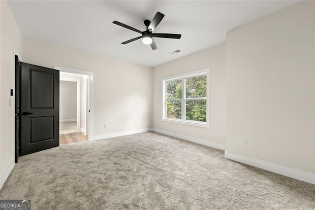 spare room with light carpet and ceiling fan