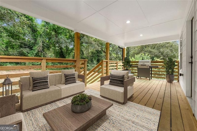 wooden terrace featuring an outdoor living space and a grill