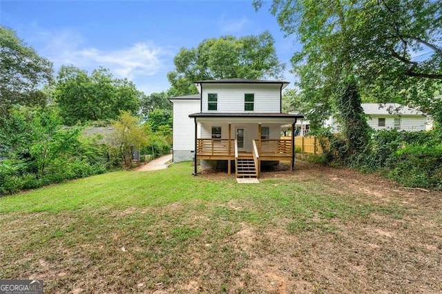 rear view of house featuring a lawn and a deck