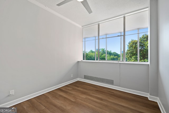 empty room with ornamental molding, ceiling fan, hardwood / wood-style floors, and a textured ceiling