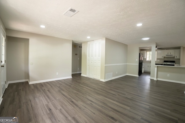 unfurnished living room featuring a textured ceiling and dark hardwood / wood-style floors