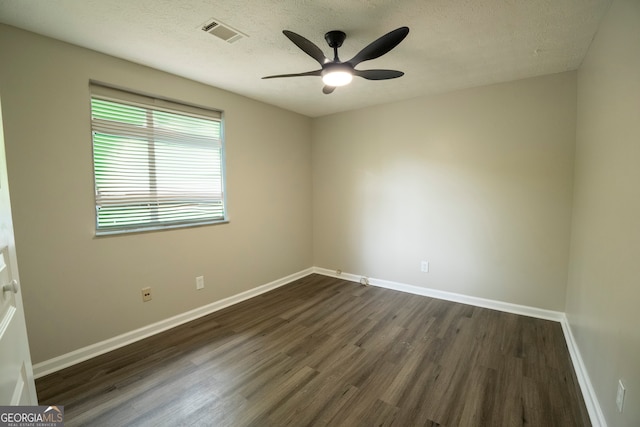 spare room with ceiling fan, a textured ceiling, and dark hardwood / wood-style floors