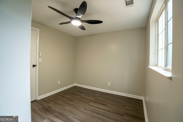 empty room with a wealth of natural light, ceiling fan, a textured ceiling, and dark hardwood / wood-style flooring