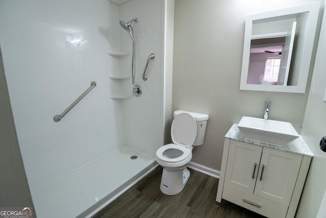 bathroom featuring hardwood / wood-style floors, vanity, a shower, and toilet