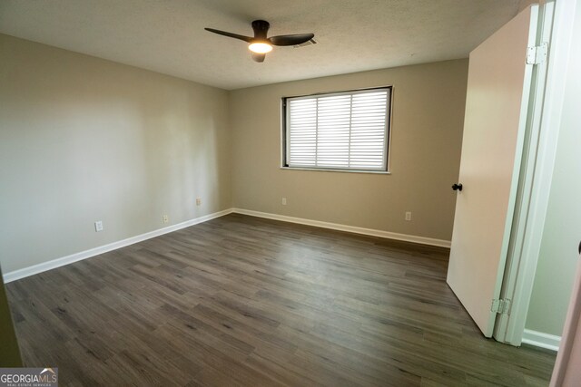 unfurnished room with a textured ceiling, ceiling fan, and dark hardwood / wood-style flooring