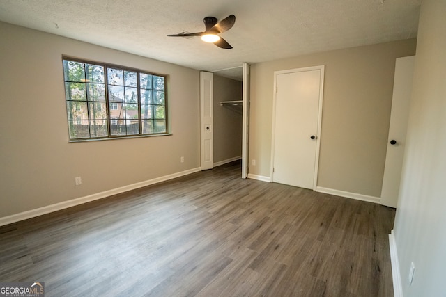 unfurnished bedroom featuring a closet, a textured ceiling, ceiling fan, and dark hardwood / wood-style flooring