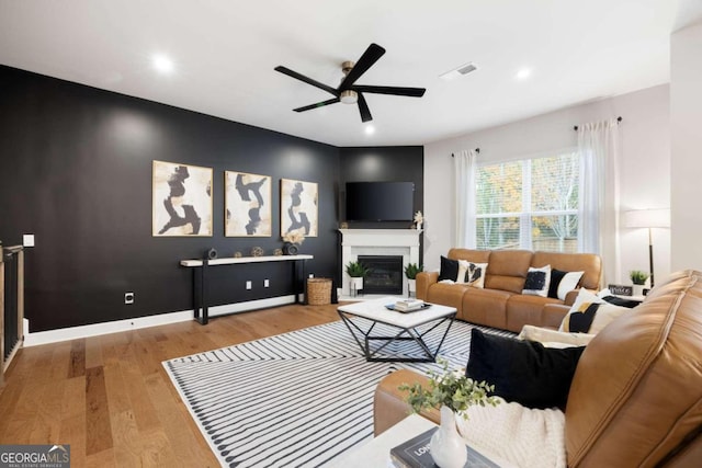 living room with light hardwood / wood-style flooring and ceiling fan