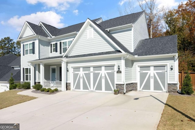 craftsman-style house featuring a front yard, a garage, and covered porch