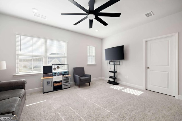 sitting room with ceiling fan and carpet flooring