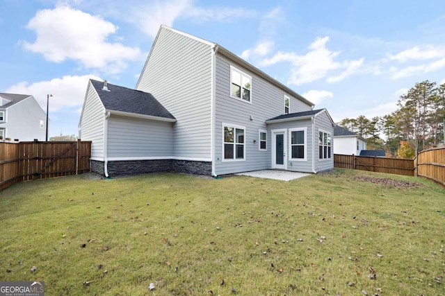 rear view of property with a yard and a patio