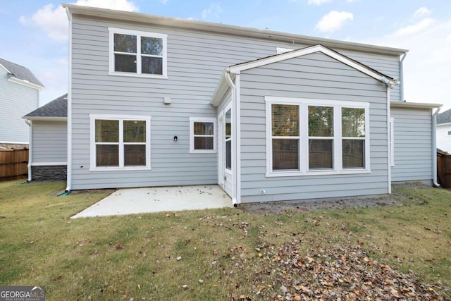 rear view of house featuring a yard and a patio