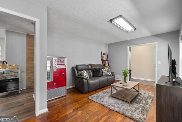 living room featuring a textured ceiling and dark wood-type flooring