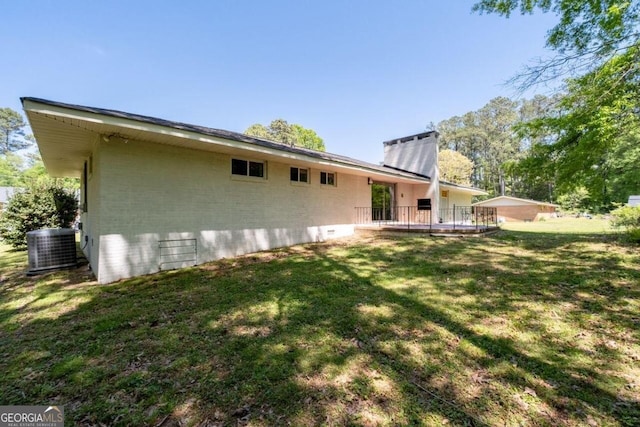 rear view of house with a lawn and central AC