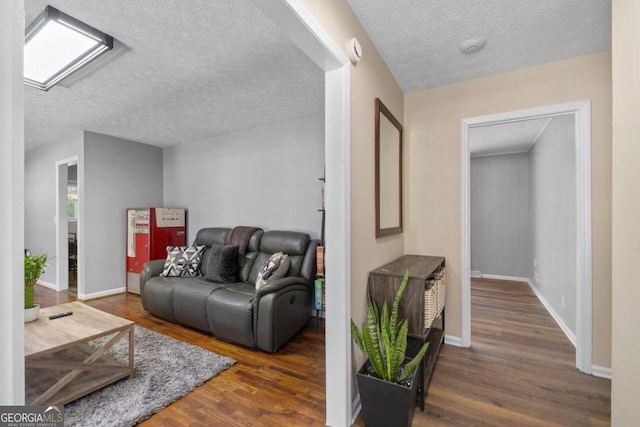 living room with a textured ceiling and dark hardwood / wood-style floors