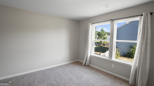 carpeted spare room featuring plenty of natural light