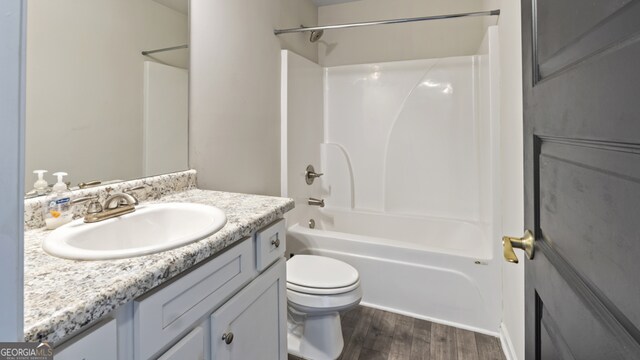 full bathroom with wood-type flooring, vanity, toilet, and shower / washtub combination