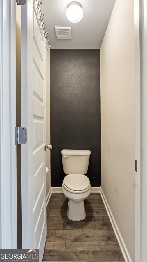 bathroom featuring hardwood / wood-style floors and toilet