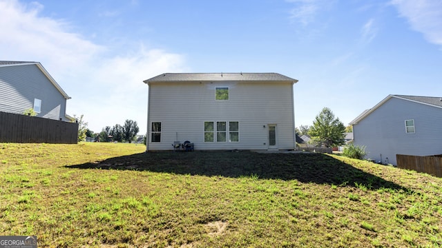 rear view of property featuring a yard