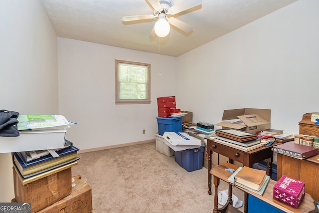 carpeted home office featuring ceiling fan