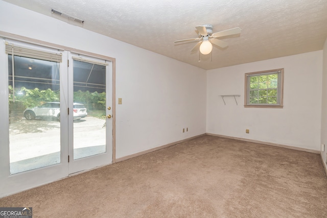 carpeted spare room featuring ceiling fan and a textured ceiling