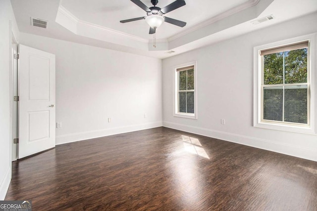 unfurnished room featuring a raised ceiling, ornamental molding, dark hardwood / wood-style floors, and ceiling fan