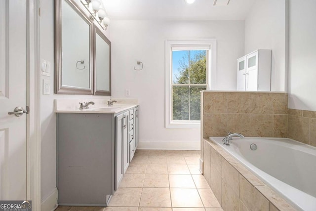 bathroom featuring tile patterned floors, tiled bath, and vanity