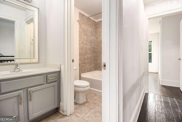 full bathroom with tiled shower / bath combo, vanity, toilet, and hardwood / wood-style flooring