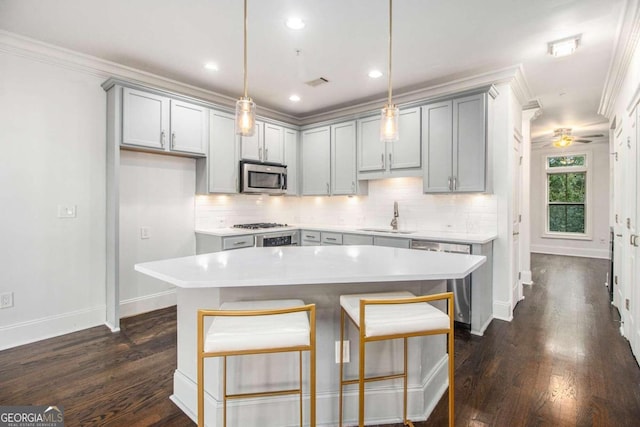 kitchen with pendant lighting, stainless steel appliances, sink, and dark hardwood / wood-style flooring