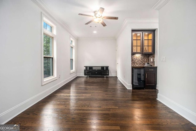 unfurnished living room with ornamental molding, beverage cooler, dark wood-type flooring, and ceiling fan