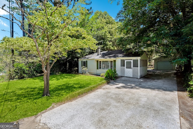 ranch-style house with a garage, an outbuilding, and a front lawn