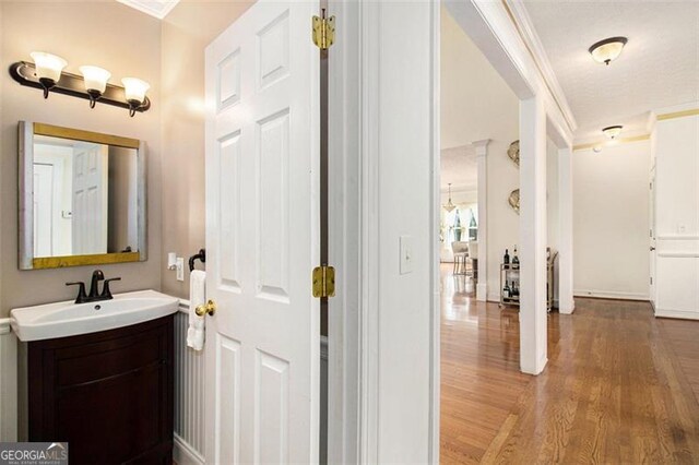 bedroom with wood-type flooring, ceiling fan, a raised ceiling, and crown molding