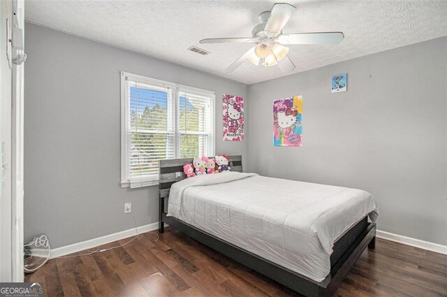 bedroom with vaulted ceiling, a closet, a textured ceiling, ceiling fan, and dark hardwood / wood-style floors