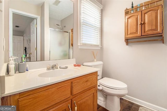 bathroom featuring wood-type flooring, an enclosed shower, vanity, and toilet