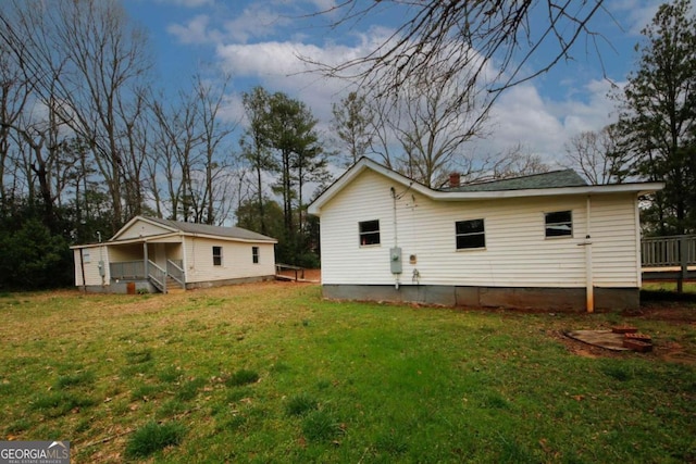 rear view of property with a lawn