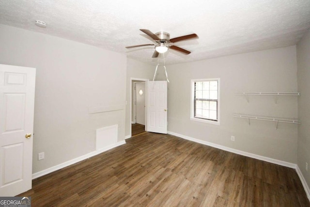 unfurnished room featuring ceiling fan, a textured ceiling, and dark hardwood / wood-style flooring