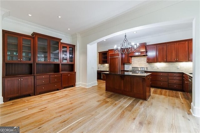 kitchen with crown molding, light hardwood / wood-style flooring, decorative light fixtures, and custom exhaust hood