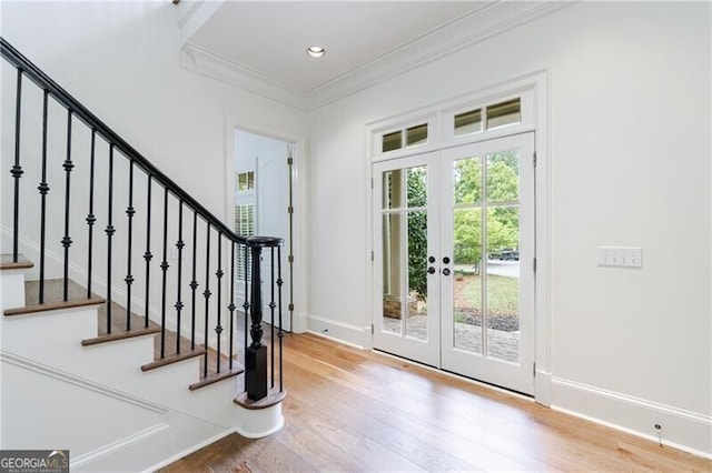 foyer entrance with hardwood / wood-style floors, french doors, and ornamental molding