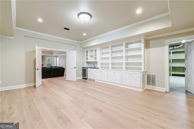 unfurnished living room with light hardwood / wood-style flooring and ornamental molding