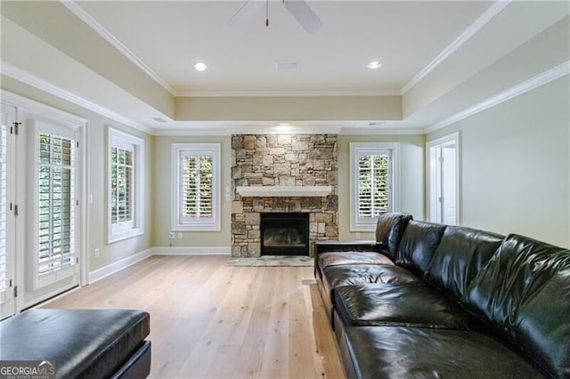 living room featuring ornamental molding, light hardwood / wood-style floors, and a healthy amount of sunlight