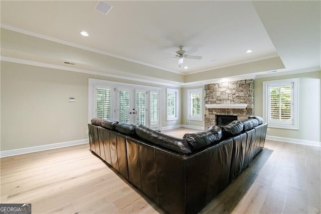 living room featuring a wealth of natural light, ornamental molding, and light wood-type flooring