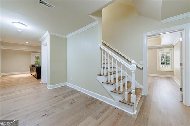 stairway with hardwood / wood-style floors and crown molding